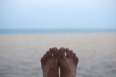 Low section of person relaxing on beach