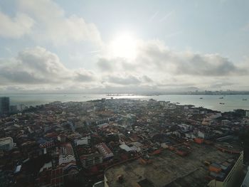 High angle view of townscape by sea against sky