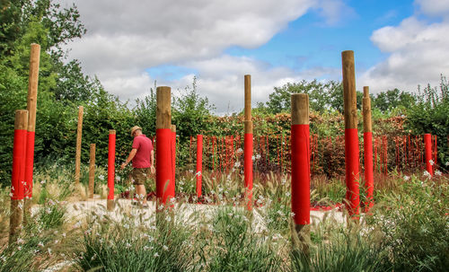 Red wooden fence on field against sky