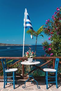 Empty chairs and table against sea 