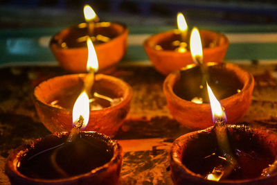 Close-up of lit diyas on table