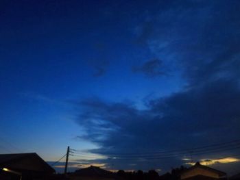 Low angle view of silhouette roof against sky