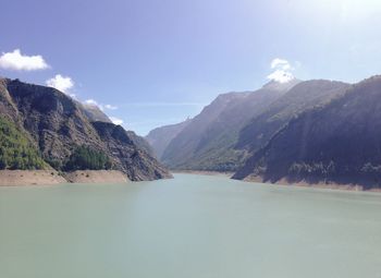 Scenic view of river and mountains against sky