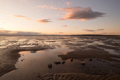 Scenic view of beach against sky during sunset