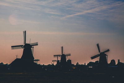 Silhouette traditional windmill against sky at sunset