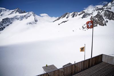 Snow covered houses and mountains against sky