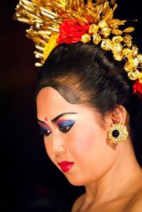 Close-up portrait of woman over black background