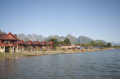 Scenic view of lake by buildings against clear sky