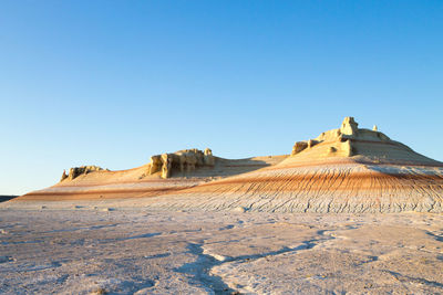 Scenic view of desert against clear blue sky