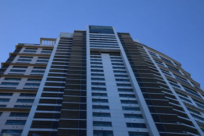 Low angle view of modern building against clear blue sky