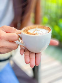 Close-up of hand holding coffee cup
