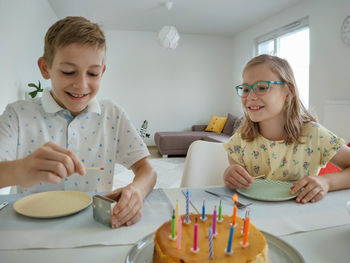 Smiling sibling celebrating birthday at home