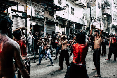 People on street against buildings in city