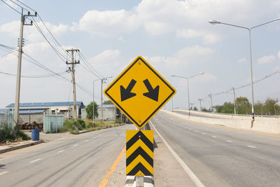 Close-up of road sign against sky