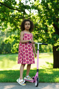 Portrait of young woman standing against trees