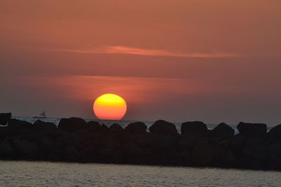 Scenic view of sea against orange sky