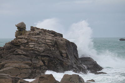 Rock formation in sea against sky