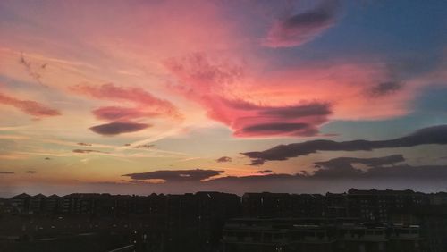 Silhouette buildings against sky during sunset