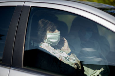 Rear view of man seen through car window