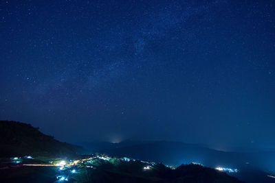 Scenic view of illuminated mountains against star field at night