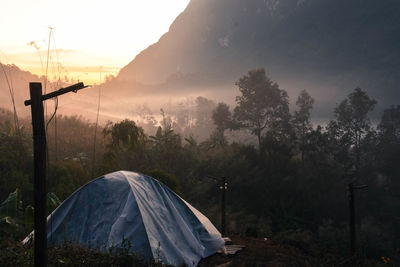 Tent on land against sky during sunset