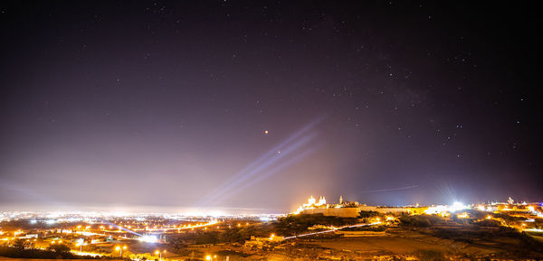 Panoramic view of illuminated buildings against sky at night