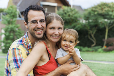 Portrait of happy family sitting at park