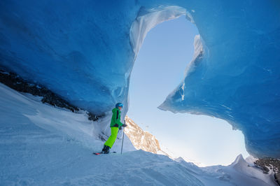 Rear view of man skiing on snowcapped mountain
