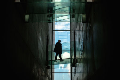 Rear view of man looking through window