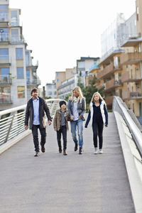 Family with two kids walking on footbridge