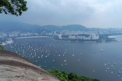 High angle view of city by sea against sky