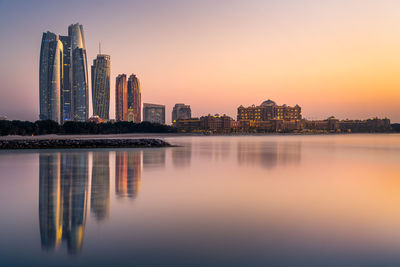 View of abu dhabi tranquil city skyline reflection at sunset