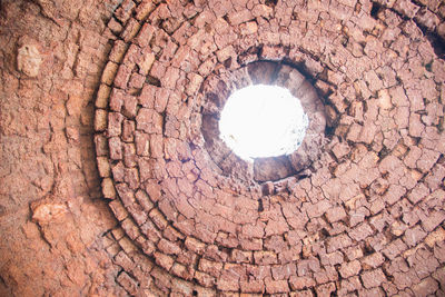 Low angle view of stone wall with hole