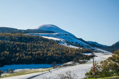 Scenic view of snowcapped mountains against clear blue sky