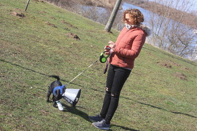 Full length portrait of man holding umbrella on field