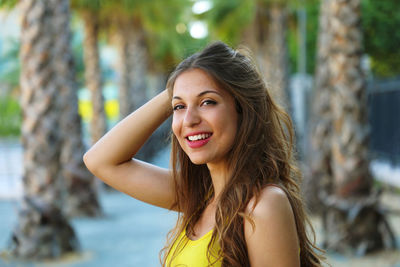 Portrait of beautiful woman smiling while standing at beach