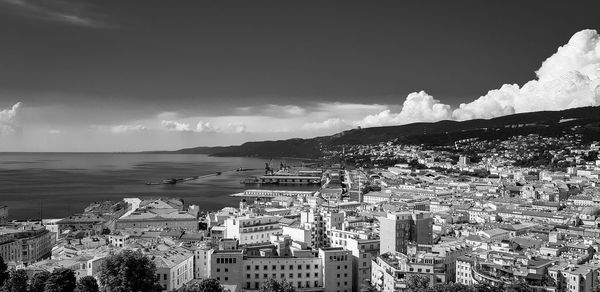 High angle view of townscape by sea against sky