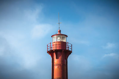 Low angle view of lighthouse by building against sky