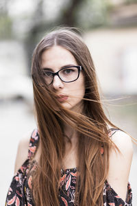 Young brown-haired millennial with glasses and light dress