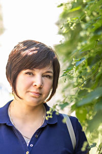 Portrait of a young woman with a short haircut in greenery close-up.spring.