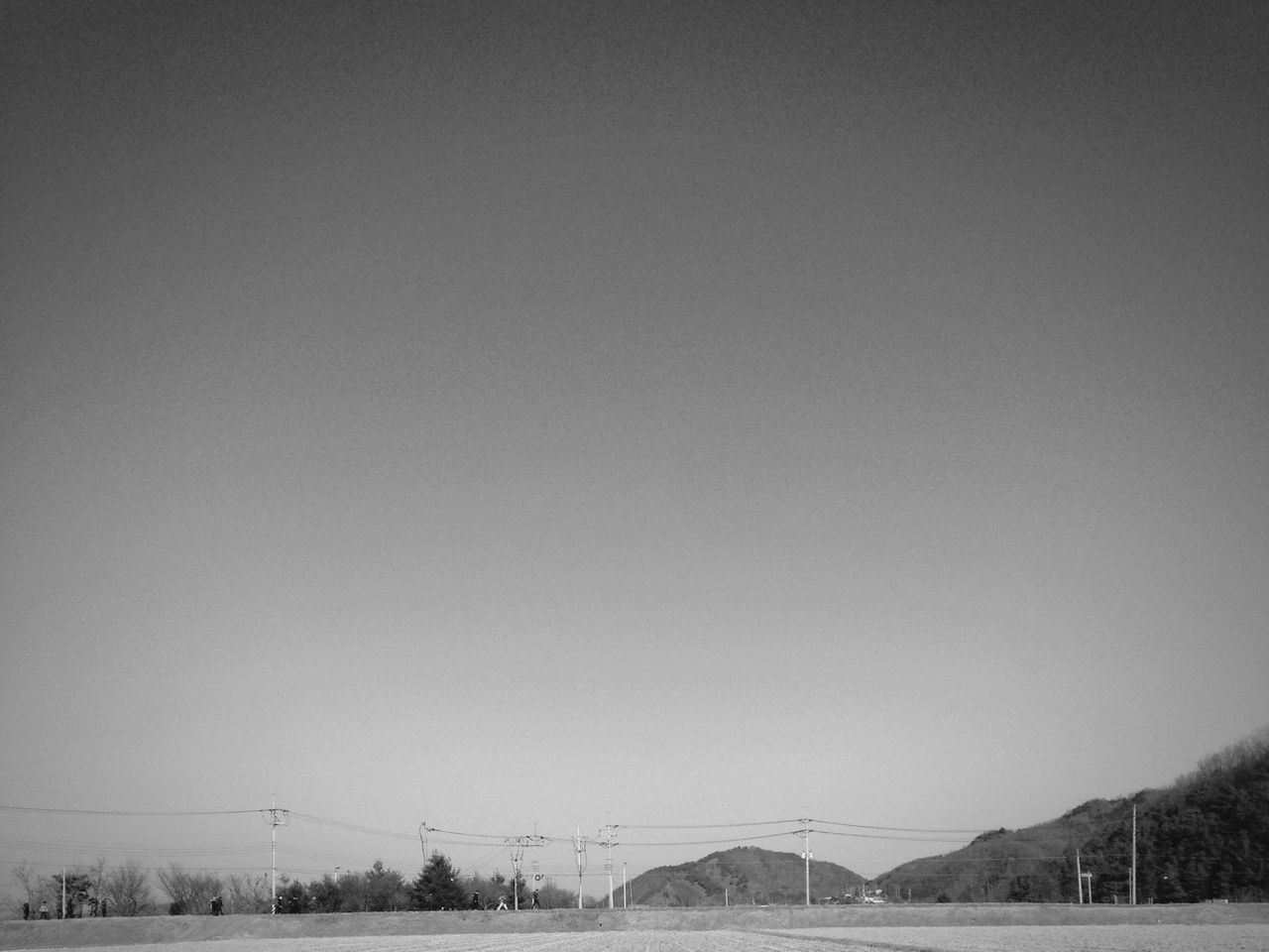 copy space, clear sky, electricity pylon, power line, connection, electricity, tranquility, landscape, fuel and power generation, tranquil scene, power supply, nature, built structure, sky, low angle view, outdoors, field, scenics, no people, cable