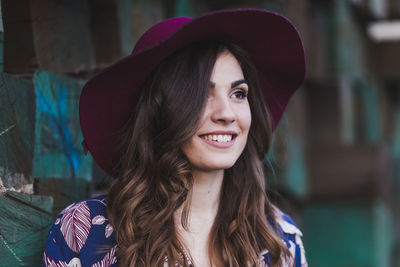 Young woman looking away against wood