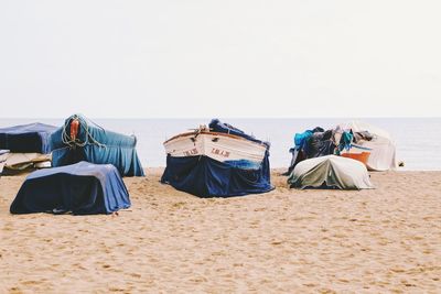 Rear view of people on beach against clear sky