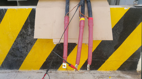 High angle view of yellow sign hanging on metal