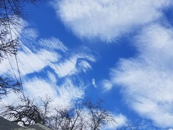 Low angle view of bare tree against cloudy sky