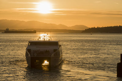 Boat on sea against sky during sunset