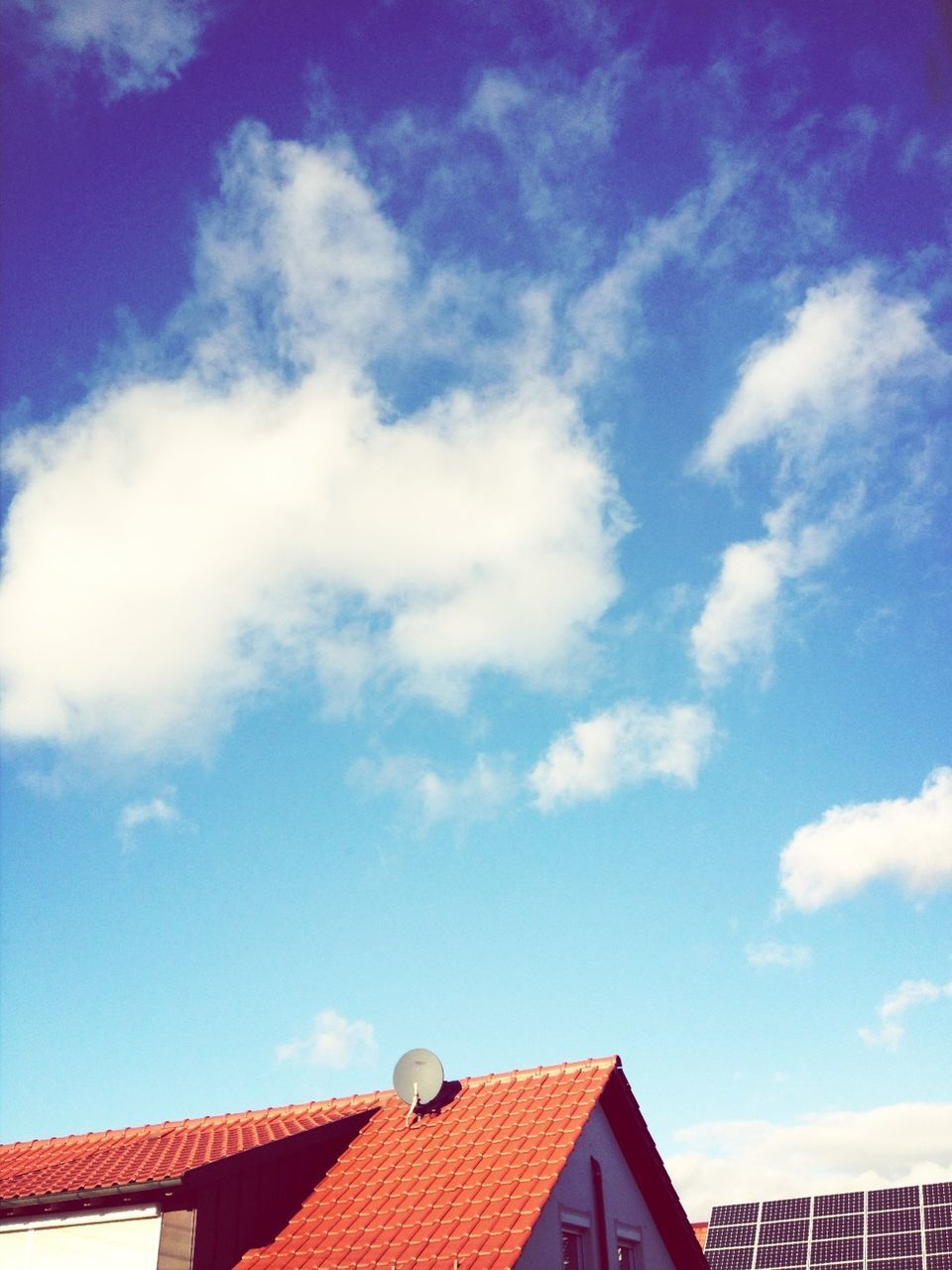 building exterior, architecture, built structure, low angle view, roof, sky, house, residential structure, high section, residential building, blue, cloud - sky, cloud, building, outdoors, day, roof tile, bird, no people, animal themes