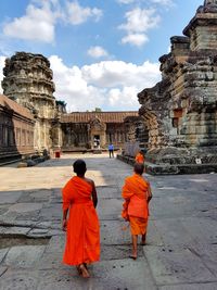 Rear view of people in temple against sky