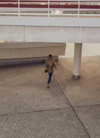 Rear view of woman walking on footpath in city