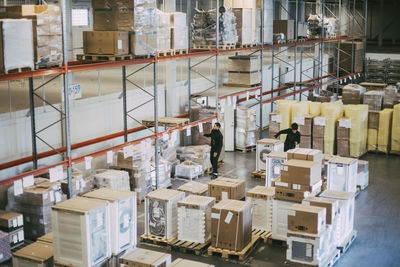 Female and male colleagues examining packages at distribution warehouse